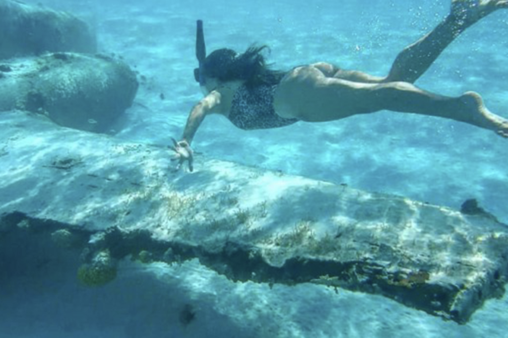sunken plane woman swiming around it