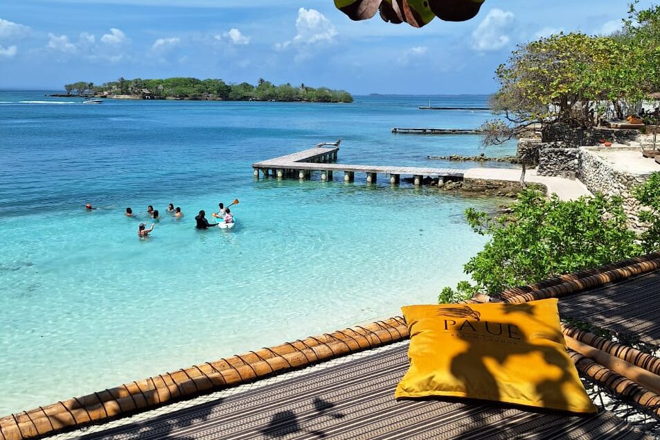 lounging net overlooking tuquoise beach with dock on the background